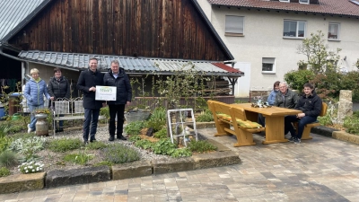 Hier kann man es aushalten: die neue Eichenholz-Sitzgruppe neben St. Bartholomäus in Mistelgau mit Landrat Wiedemann und Bürgermeister Lappe (stehend im Vordergrund) (Foto: Horst Mayer)