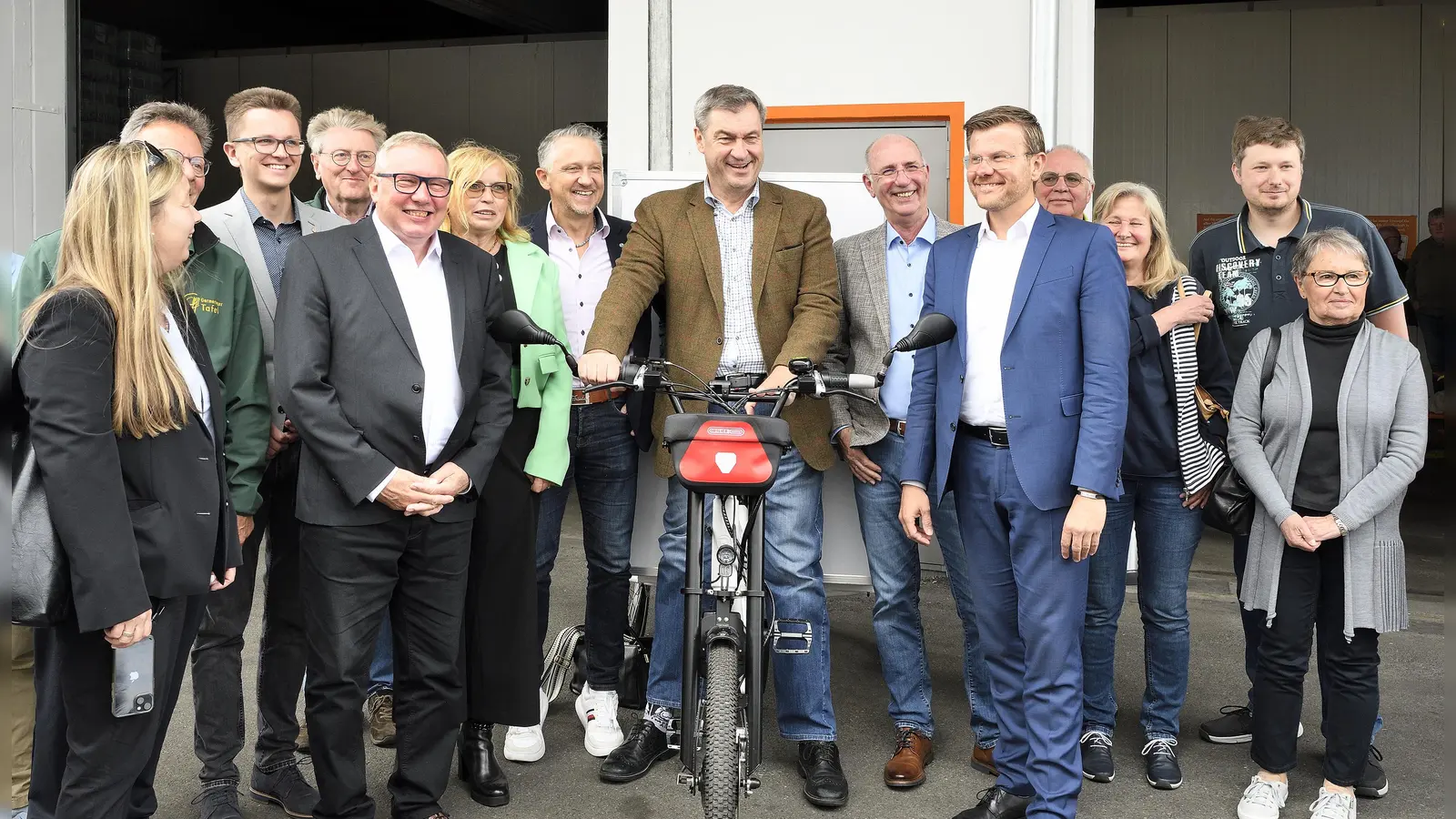 Im Rahmen der Eröffnung kam es auch zur Übergabe von acht Elektro-Lastenrädern. V.l.: Jonah Lindinger, stellvertretende Vorsitzende Tafel Deutschland e.V., Alex Brunner,<br>stellvertretender Vorsitzender Tafel Bayern e.V., Andreas Steppuhn, Vorsitzender Tafel Deutschland e.V., Gabi Schmidt, MdL Ehrenamtsbeautragte, Thomas Huber, MdL,<br>Ministerpräsident Dr. Markus Söder, Peter Zilles, Vorsitzender Tafel Bayern e.V., Marcus König, Oberbürgermeister Stadt Nürnberg.  (Foto: Jörg Weber, wbr-Studio)