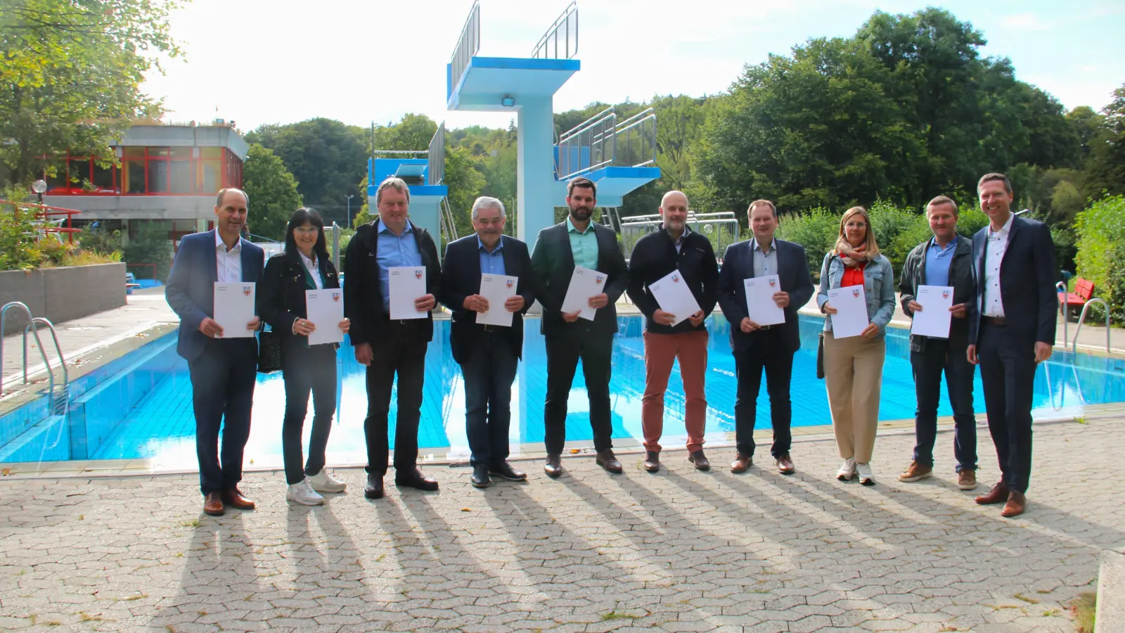 V.l.:. Hartmut Stern (Bürgermeister Hollfeld), Sybille Pichl (Bürgermeisterin Eckersdorf), Karl Lappe (Bürgermeister Mistelgau, Vertreter für die Therme Obernsees), Günter Dörfler (2. Bürgermeister Weidenberg), Christian Weber (Bürgermeister Pottenstein), Claus Meyer (Bürgermeister Betzenstein), Christian Porsch (Bürgermeister Speichersdorf), Dr. Sandra Huber (2. Bürgermeisterin Pegnitz), Andreas Heißinger (2. Bürgermeister Gefrees) und Landrat Florian Wiedemann freuen sich im Betzensteiner Freibad über die Schwimmförderbescheide für das Jahr 2023. (Foto: red )